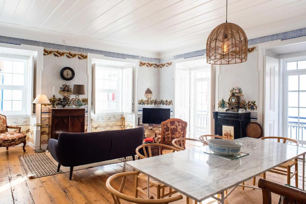 a living room with a table and chairs at Central 3 Bedroom Apartment in Ericeira in Ericeira