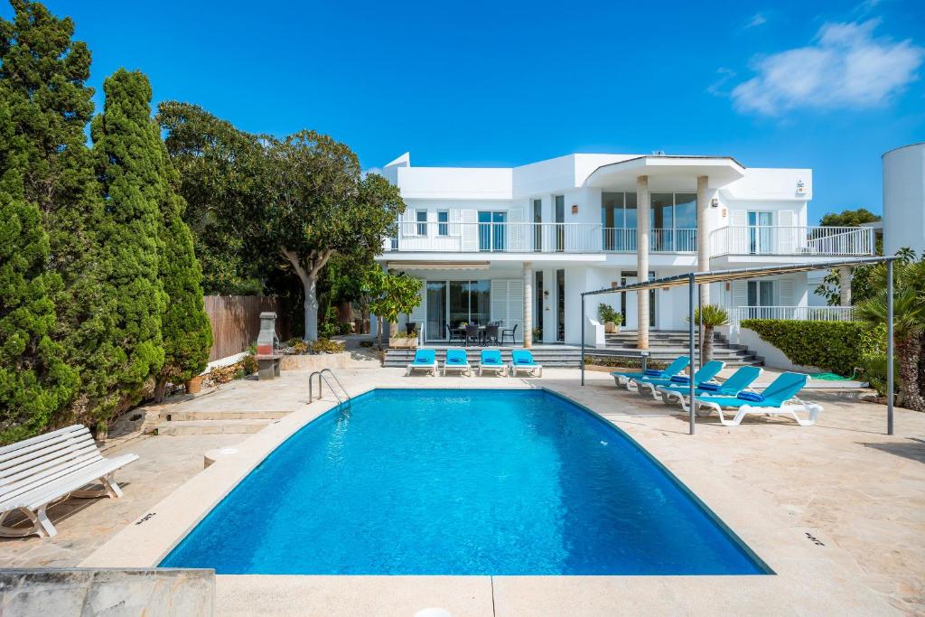 a villa with a swimming pool and a house at Des Port - Vistas al mar in Portopetro