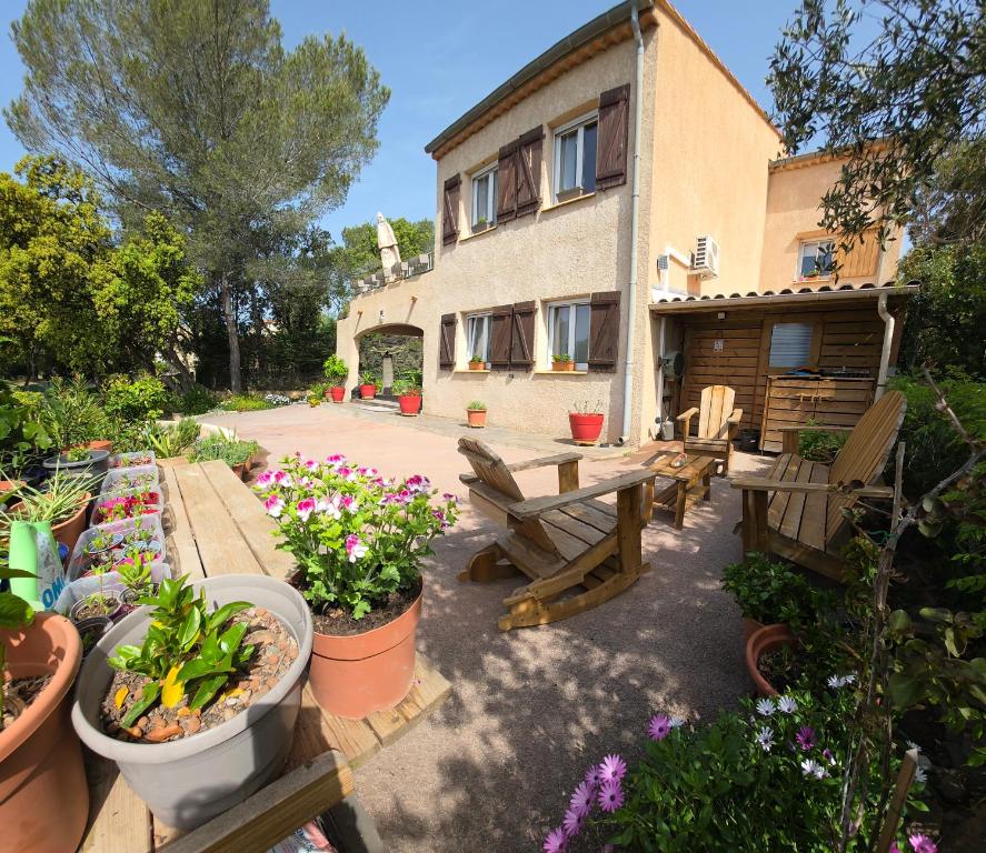 un jardin avec des plantes en pot et un bâtiment dans l'établissement Entire ground floor in beautiful villa, à Saint-Raphaël
