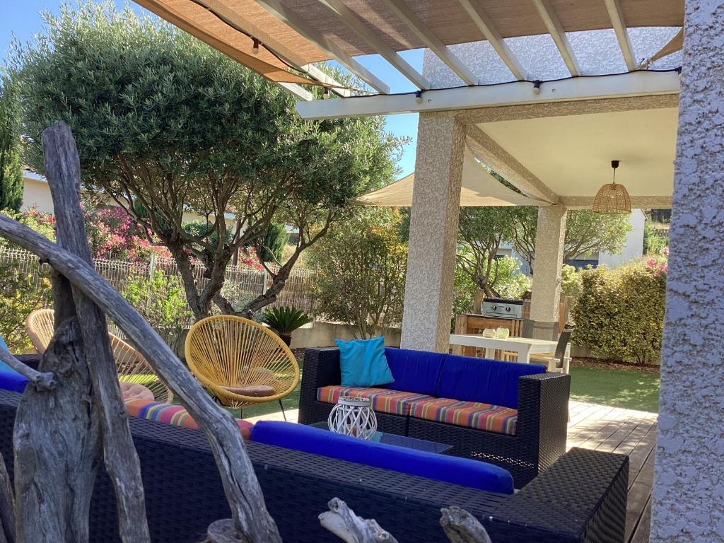 une terrasse avec un canapé bleu et des chaises dans l'établissement Détente et soleil, à Lapalme