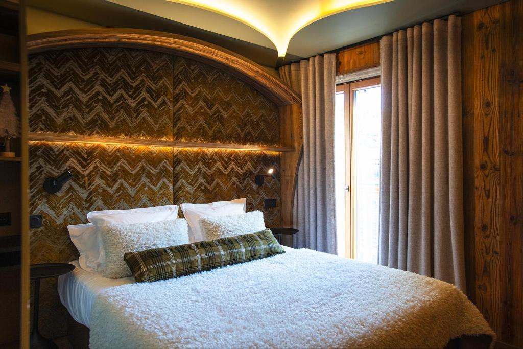a bedroom with a bed and a window at Hotel Beauregard in La Clusaz