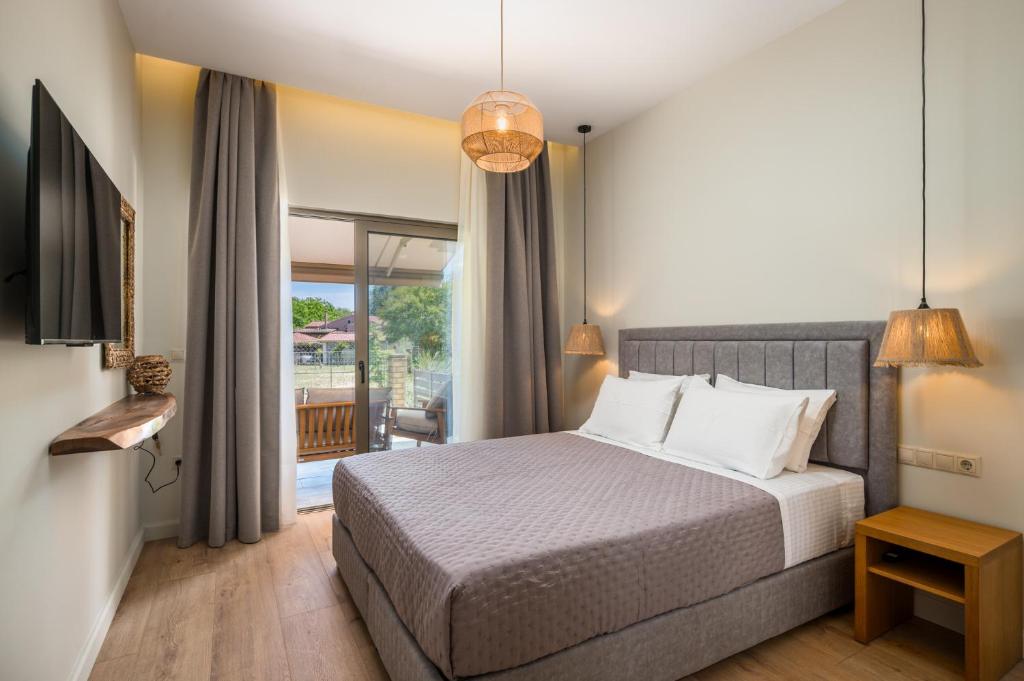 een slaapkamer met een groot bed en een balkon bij Phos Elegant Residences by Konnect, 400m to the beach in Dassia