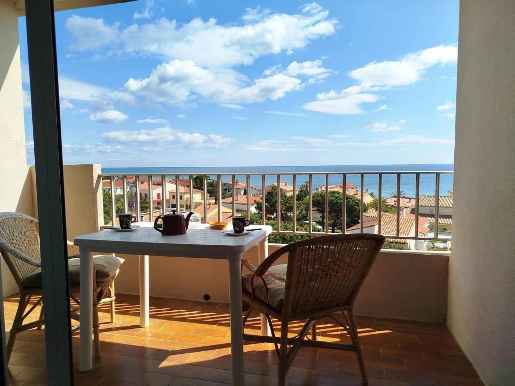 une table et des chaises sur un balcon avec vue sur l'océan dans l'établissement T2 face mer avec parking à deux pas de la plage et des commerces -4GAL502, à Saint Cyprien Plage