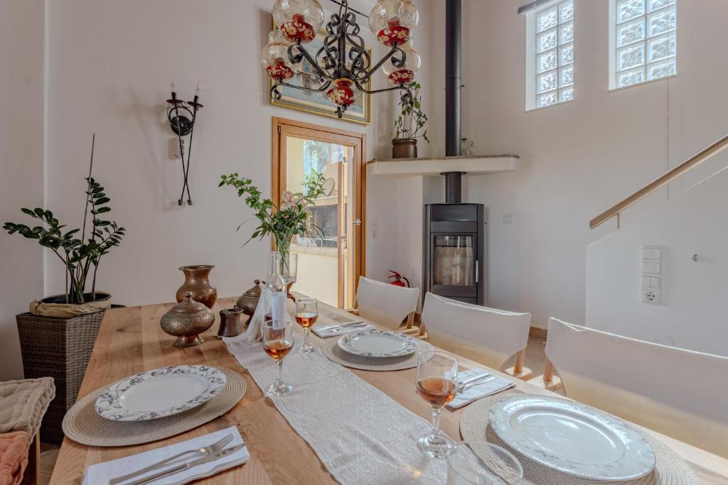 a dining room with a wooden table with wine glasses at Villa Sternfalle with jacuzzi by 8essentially in Elaía