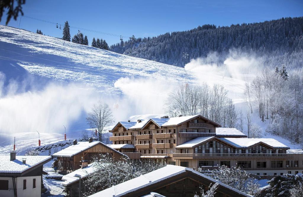 a ski lodge in the snow with a mountain at Hotel Beauregard in La Clusaz