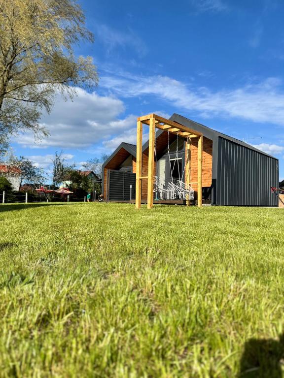 a house on a grass field with a building at ODSKOCZNIA Rewa in Rewa