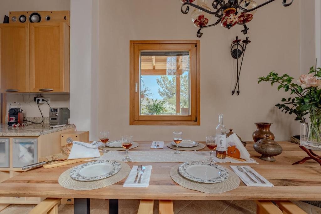 a wooden table with plates and glasses on it in a kitchen at Villa Sternfalle with jacuzzi by 8essentially in Elaía