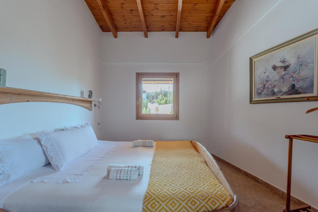 a bedroom with a white bed with a window at Villa Sternfalle with jacuzzi by 8essentially in Elaía