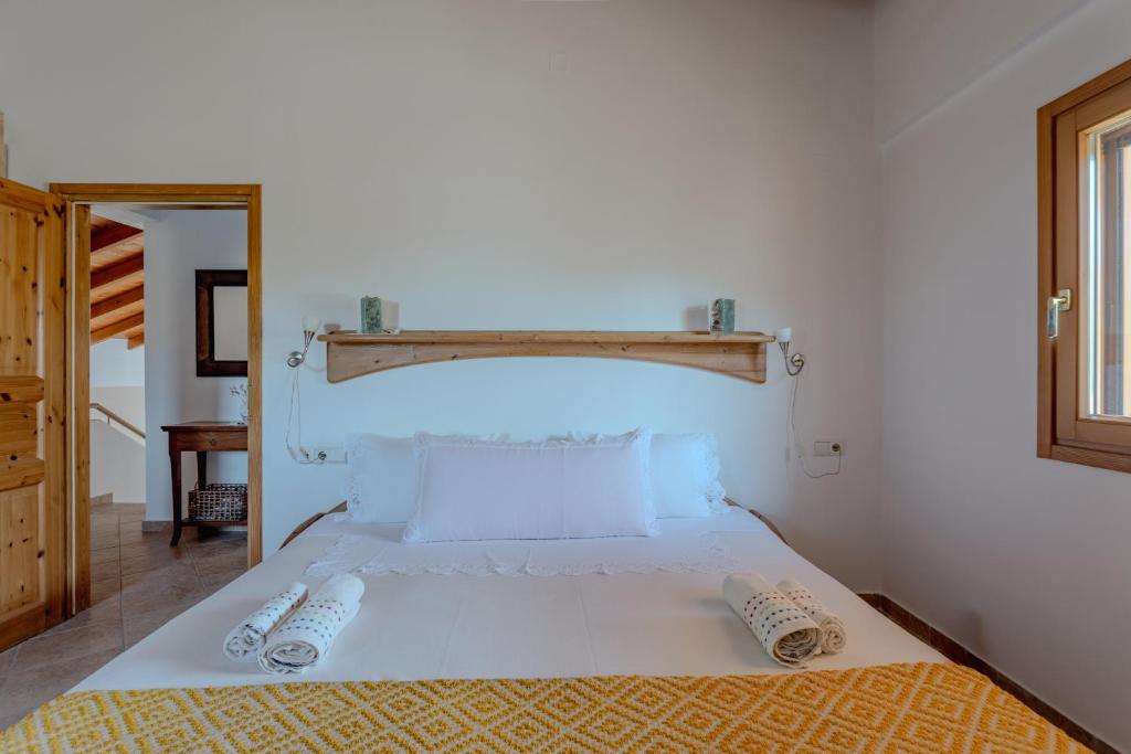 a bedroom with a white bed with two pillows on it at Villa Sternfalle with jacuzzi by 8essentially in Elaía