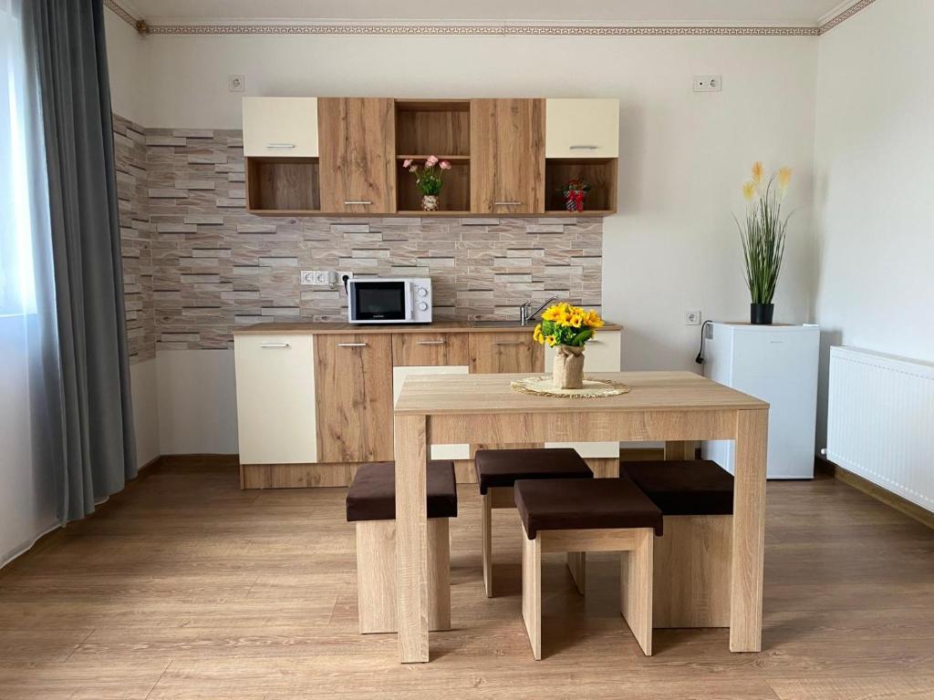 a kitchen with a wooden table and a table and chairs at Apartament Cristian in Cîmpia Turzii