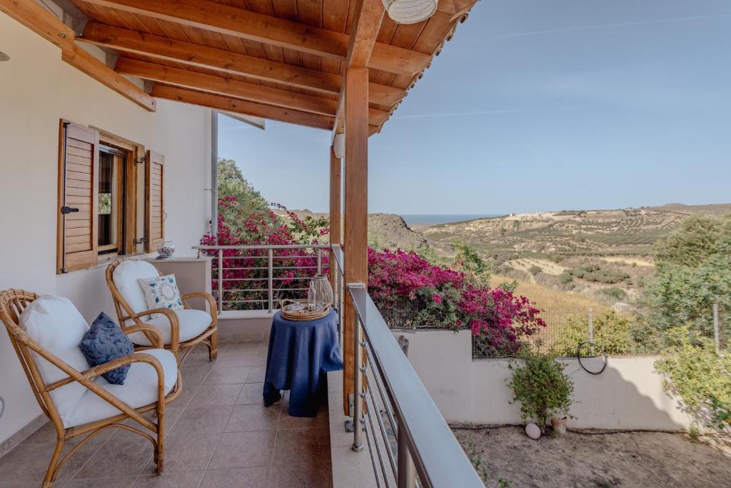 a balcony with chairs and a table with a view at Villa Sternfalle with jacuzzi by 8essentially in Elaía