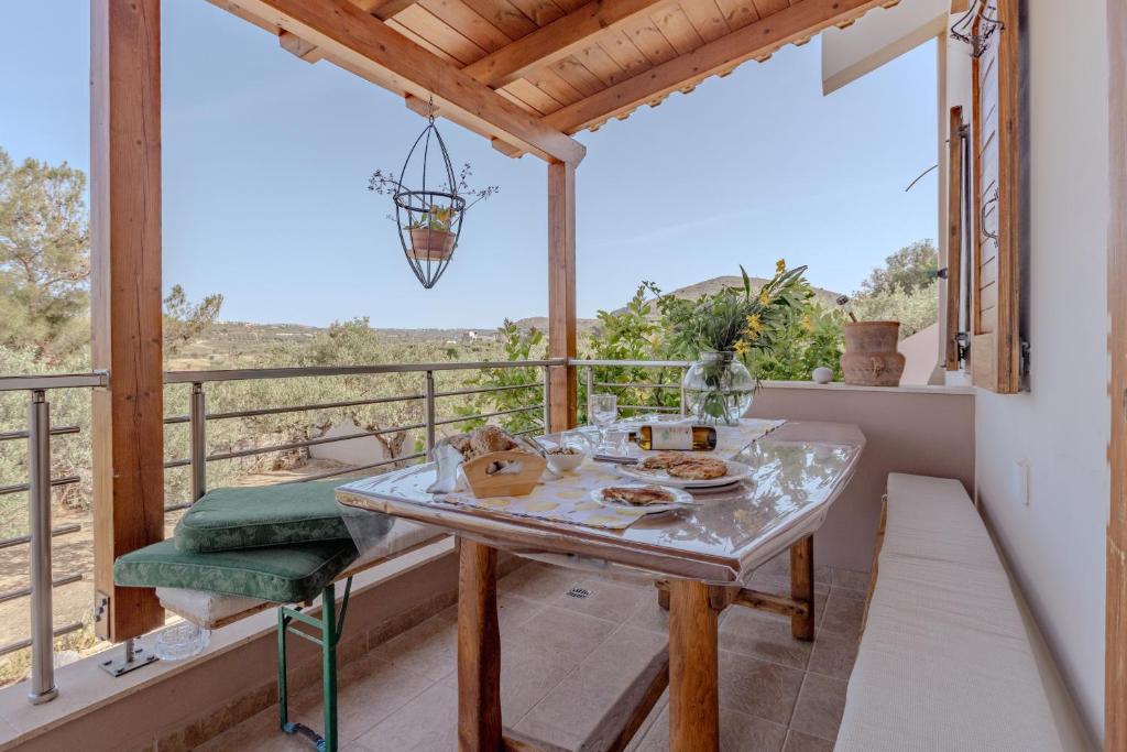 a room with a table and a balcony with a view at Villa Sternfalle with jacuzzi by 8essentially in Elaía
