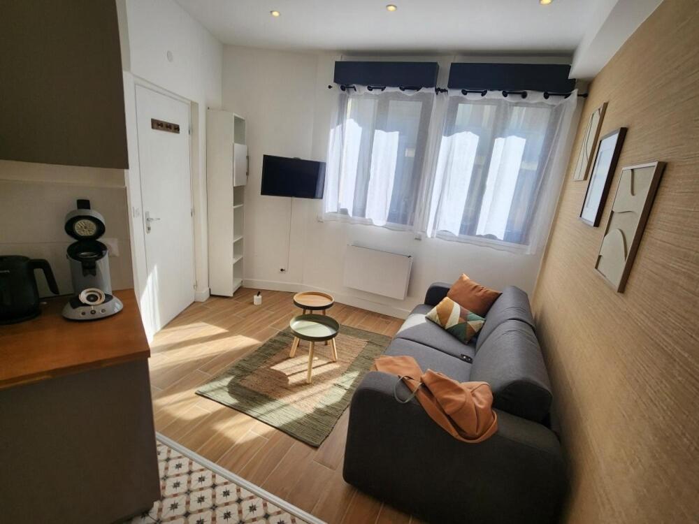 a living room with a couch and a table at Forest Studio - Ground Floor - City Center - Train station 5 minutes away in Charleville-Mézières