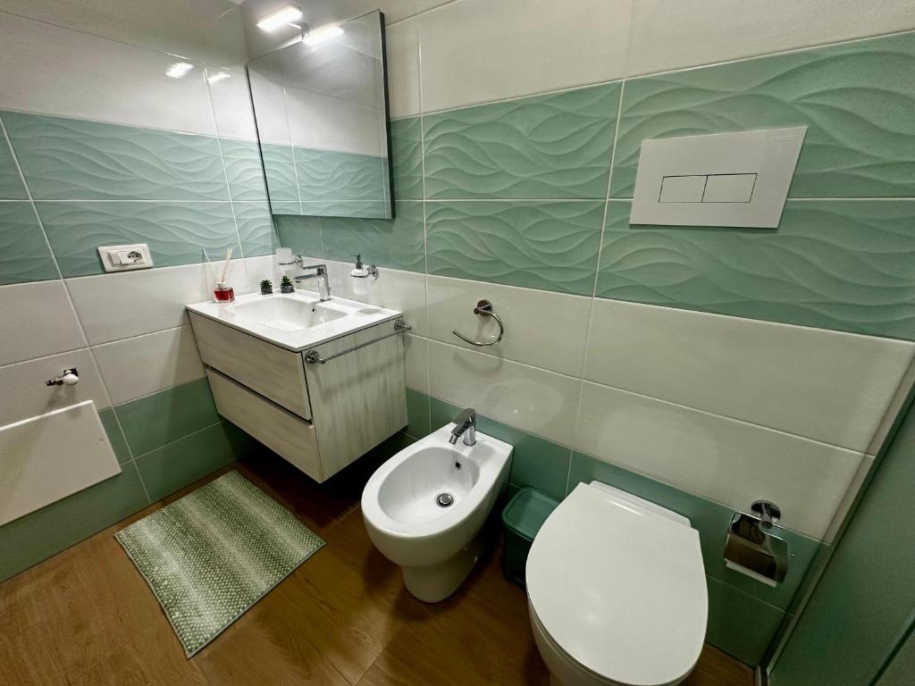 a bathroom with a toilet and a sink at Domus Apartament in Capo dʼOrlando