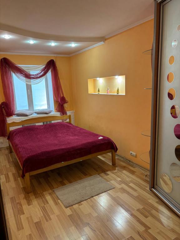 a bedroom with a bed with a window at Квартира в центрі на Волі 8А in Luts'k