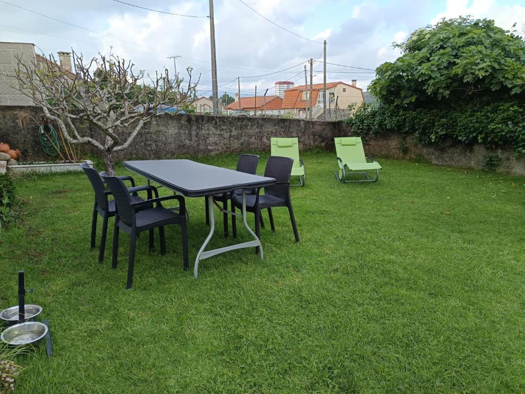 a table and chairs sitting in a yard at Casa Rural Oscar in Baiona