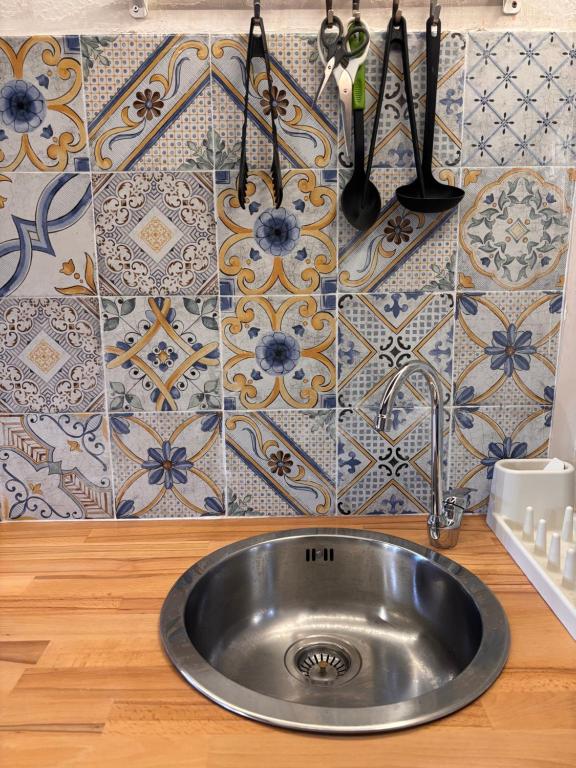 een roestvrijstalen wastafel in een keuken met tegels bij Casa San Rocco in Pitigliano