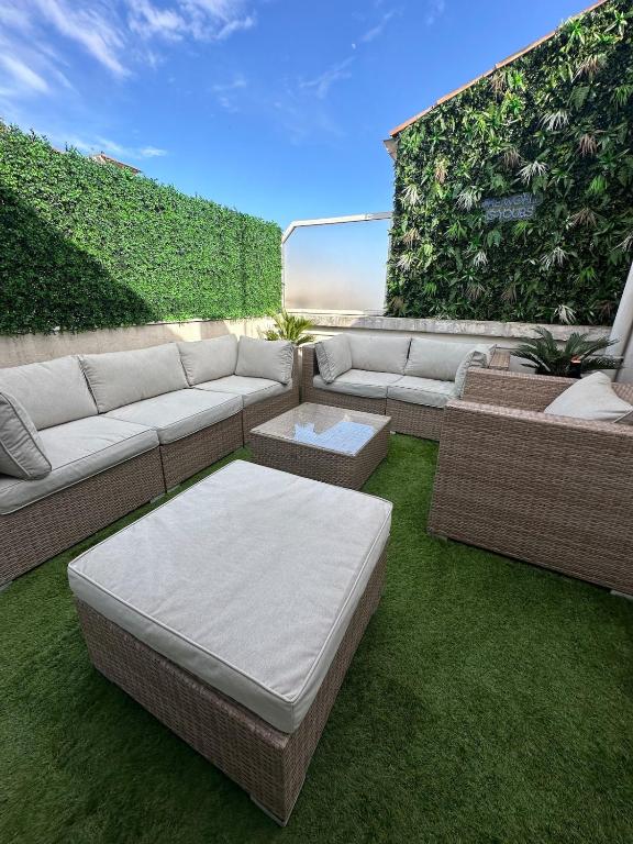 d'une terrasse avec un canapé, une table et de la pelouse. dans l'établissement Spacious, quiet apartment, à Nice