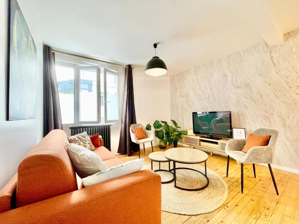 un salon avec un canapé et une télévision dans l'établissement Saint-Nazaire - La Terrasse, à Saint-Nazaire