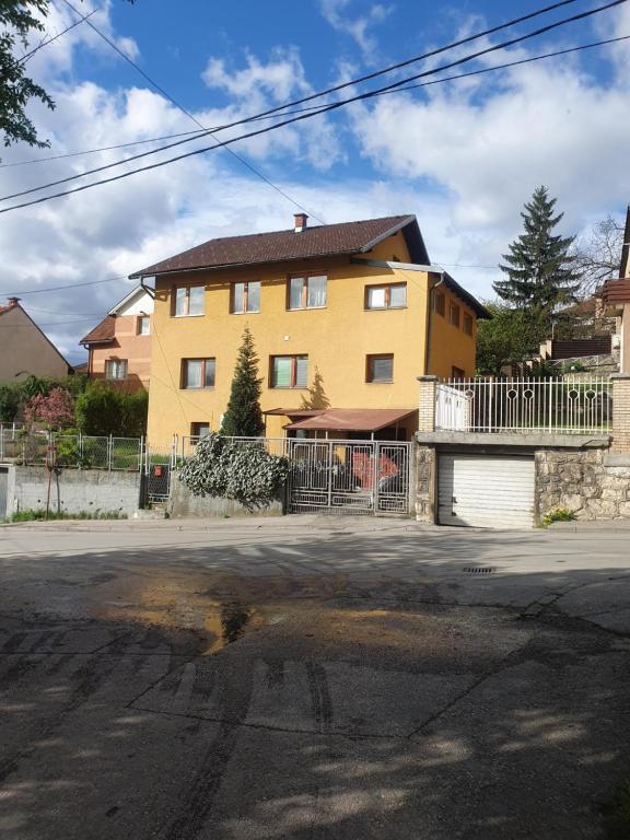 a yellow house on the side of a street at Roam&Rest Sarajevo in Sarajevo
