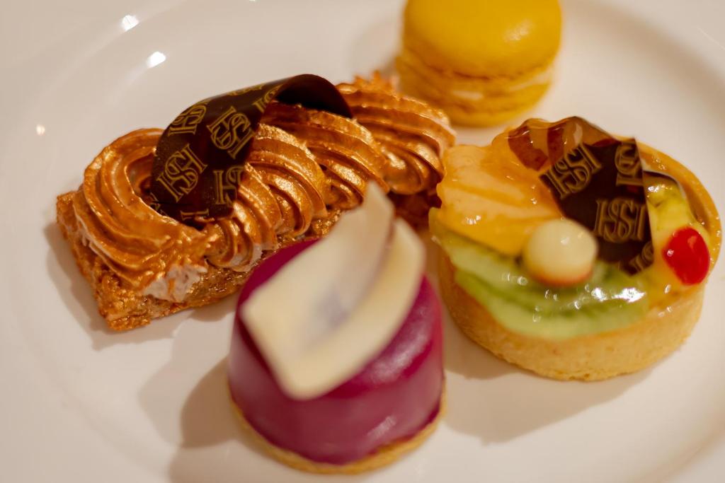 three pastries on a white plate on a table at Hotel Stadt Hamburg in Westerland
