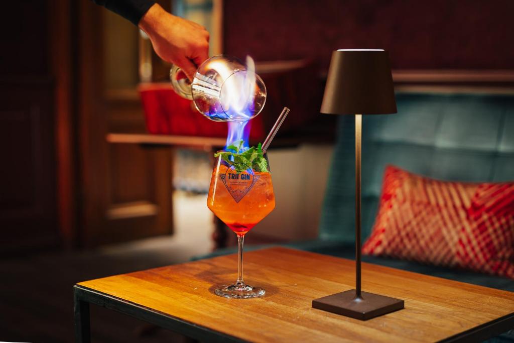 a person pouring a drink into a glass on a table at Hotel Stadt Hamburg in Westerland