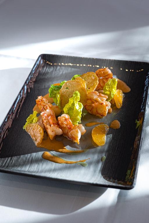 a plate of food with shrimp and vegetables on it at Hotel Stadt Hamburg in Westerland