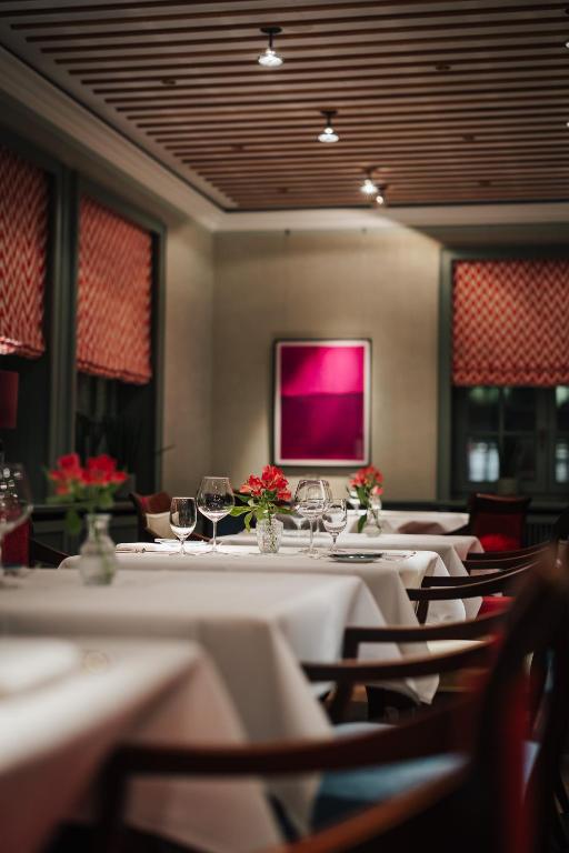 a dining room with tables and chairs with wine glasses at Hotel Stadt Hamburg in Westerland