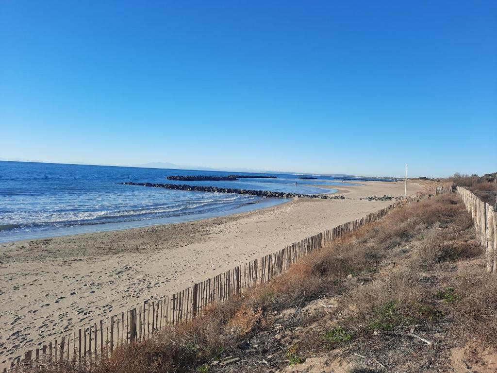 une clôture sur une plage au bord de l'océan dans l'établissement Appartement neuf et climatisé, 6 personnes, à 150m de la plage, à Vias