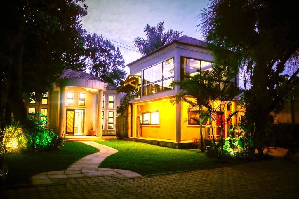 ein großes Haus mit grünem Rasen davor in der Unterkunft Zawadi House Lodge in Arusha
