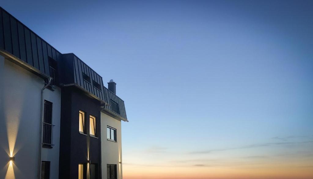 a building with the sunset in the background at Bruchersee-Gummersbach Nord in Marienheide