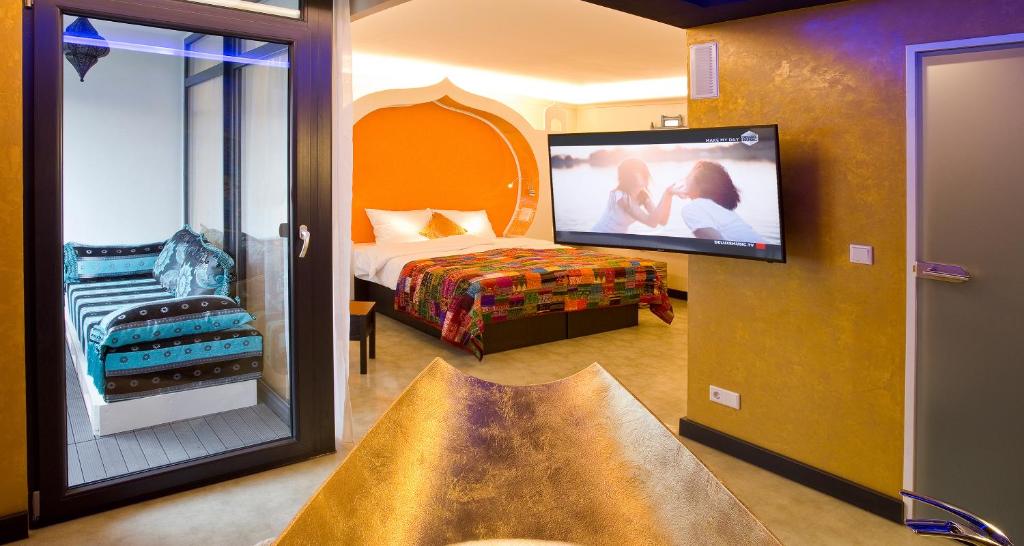 a hotel room with a bed and a flat screen tv at PLAZA INN stays design Dortmund in Dortmund