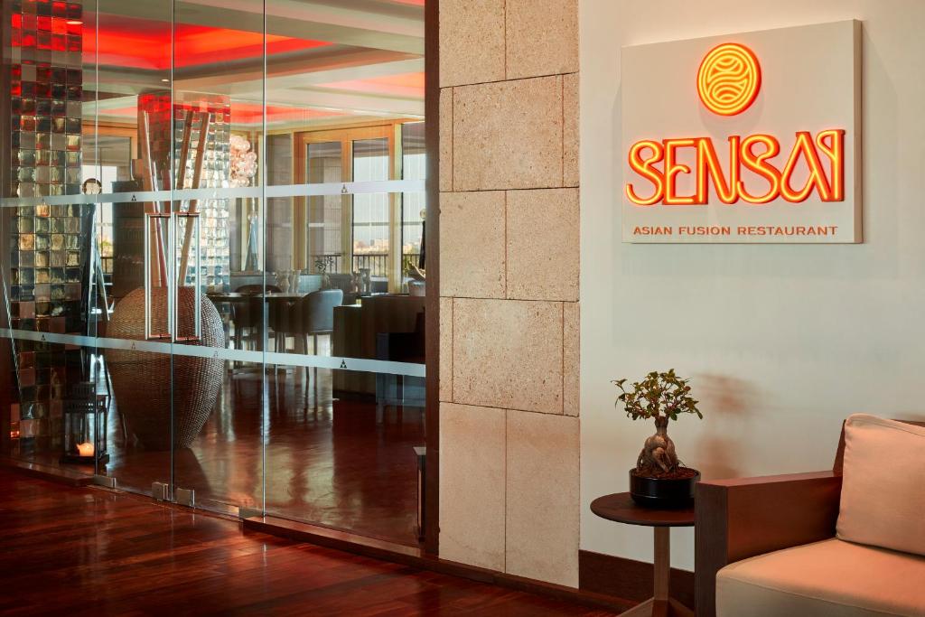 a lobby with a sign on the wall of a restaurant at Victoria Golf Resort and Spa Managed by Accor in Vilamoura