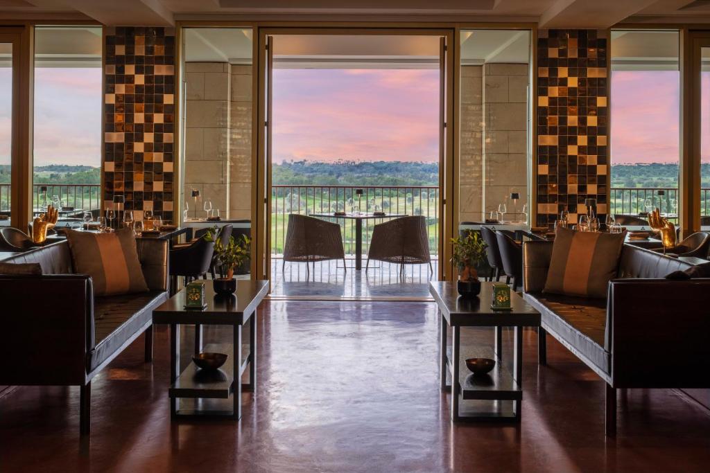 a restaurant with couches and tables with a view at Victoria Golf Resort and Spa Managed by Accor in Vilamoura