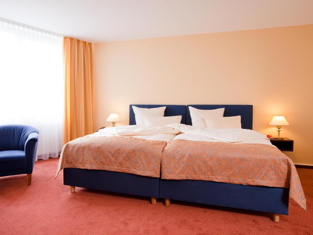 Postel nebo postele na pokoji v ubytování Carathotel Basel/Weil am Rhein