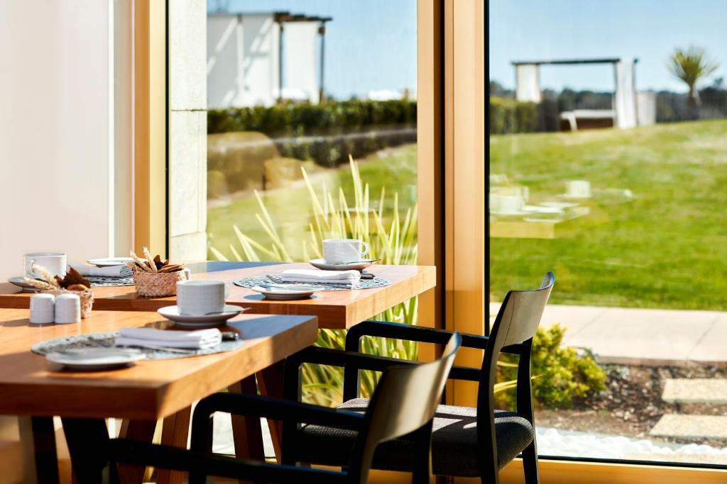 a dining room with a table and chairs and a window at Victoria Golf Resort and Spa Managed by Accor in Vilamoura