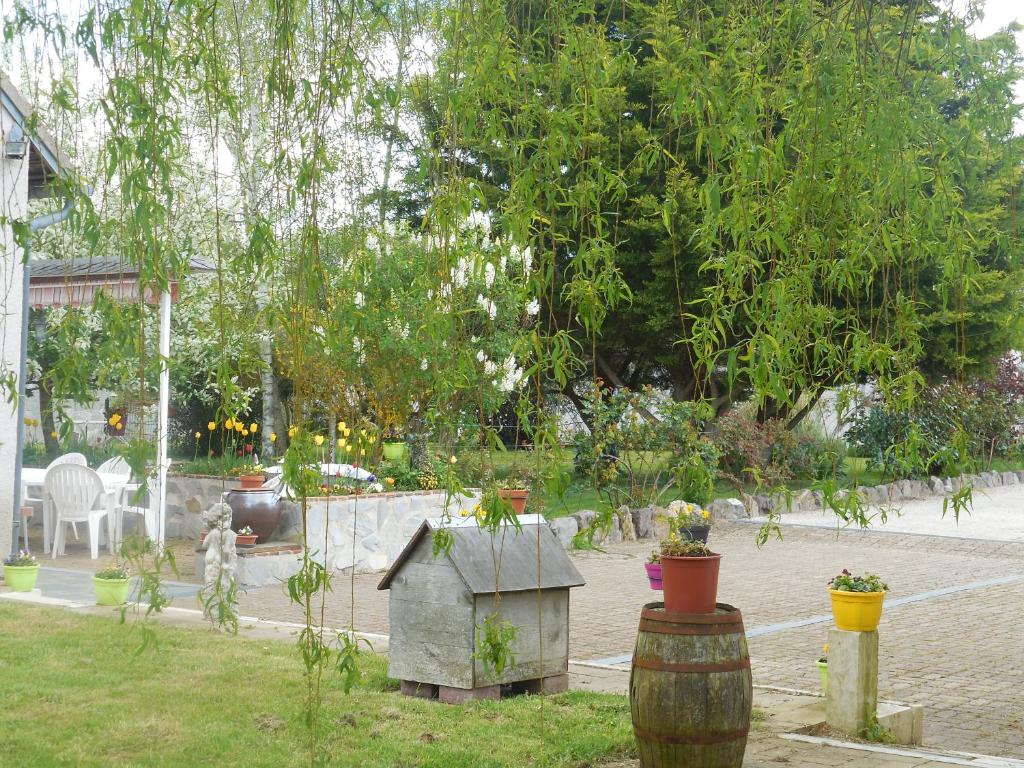 a garden with a bird house and potted plants at Les rouches in Cormeray