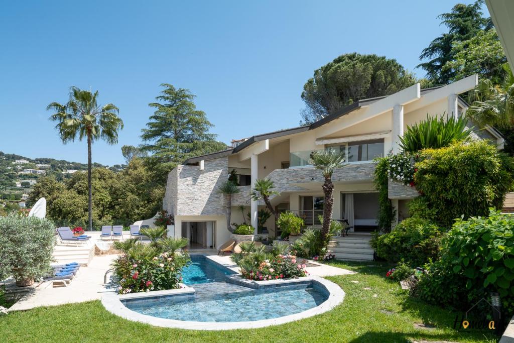 une maison avec une piscine et des palmiers dans l'établissement Villa Prestige Hammam & Piscine, à Cannes