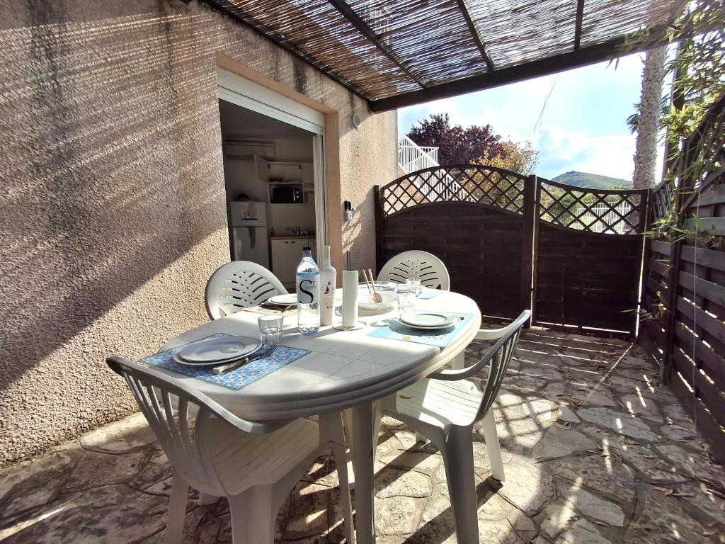 a white table and chairs on a patio at SAINT-FLORENT 2 Pièces terrasse piscine FLO300-J07 in Saint-Florent