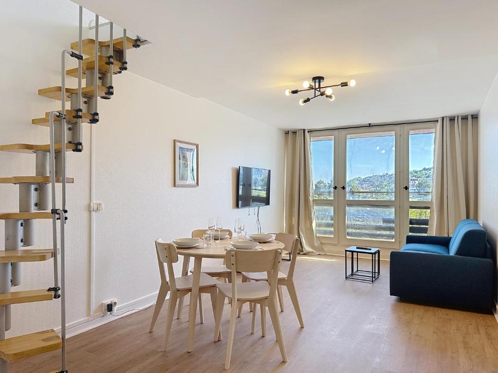 une salle à manger et un salon avec une table et des chaises dans l'établissement Les Voiles YourHostHelper, à Deauville