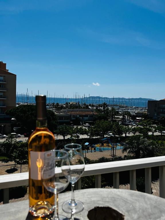 une bouteille de vin posée sur une table avec deux verres dans l'établissement La Marine' Hyères, à Hyères