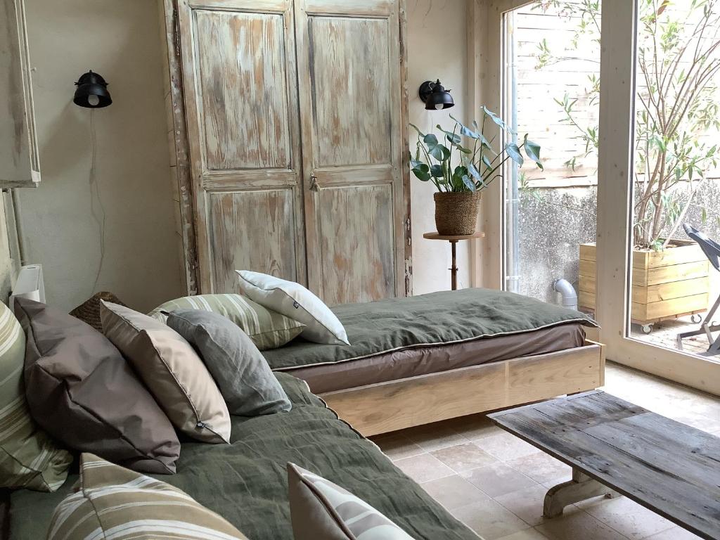 une chambre avec deux lits, une table et une fenêtre dans l'établissement Maison G, à Montréal