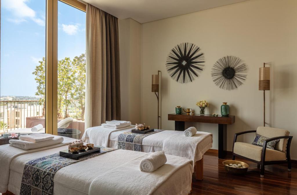 a hotel room with three beds and a window at Victoria Golf Resort and Spa Managed by Accor in Vilamoura