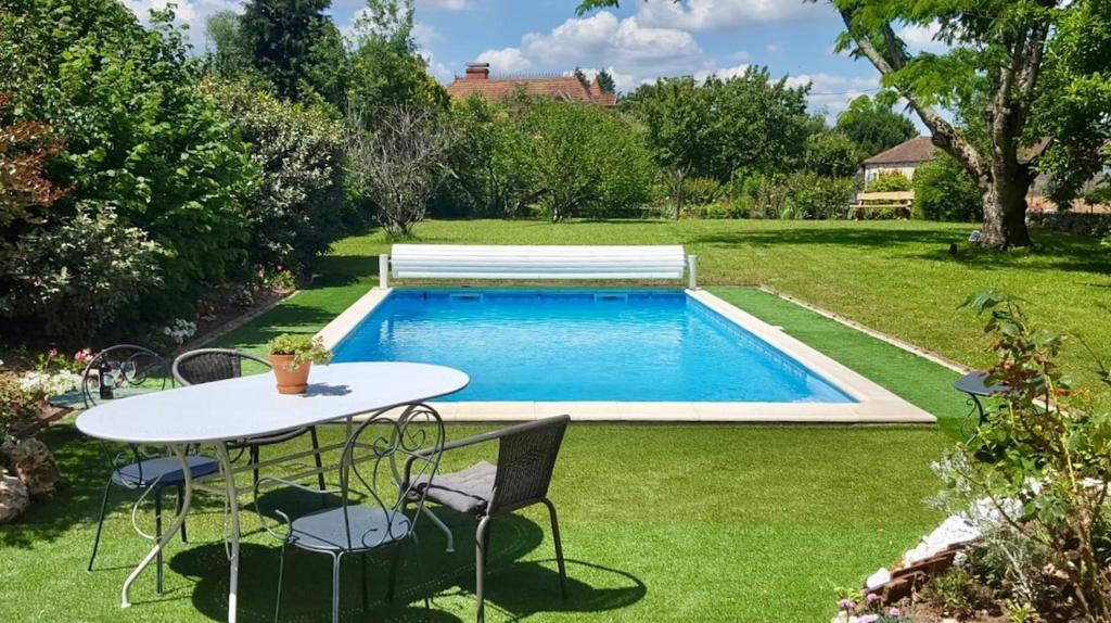 - une petite piscine dans une cour avec une table et des chaises dans l'établissement Mas de Fantou, à Anglars-Juillac