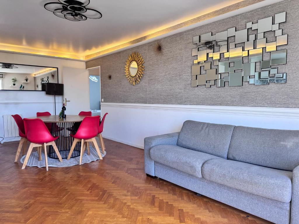 - un salon avec un canapé et une table avec des chaises rouges dans l'établissement FELLINI 3BR with safe parking, à Saint-Denis