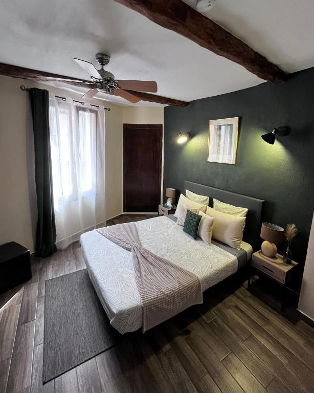 a bedroom with a bed and a ceiling fan at Lou Mistral - chambres de charme climatisées, centre historique in Moustiers-Sainte-Marie