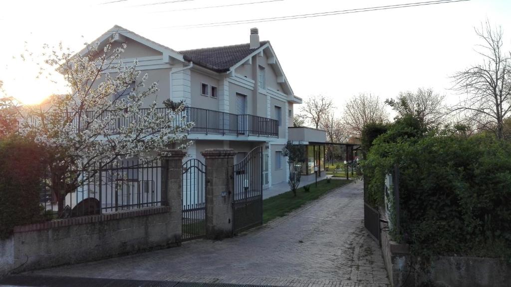 ein weißes Haus mit einem Zaun neben einer Straße in der Unterkunft Guesthouse il Ciliegio in Sorbo Serpico