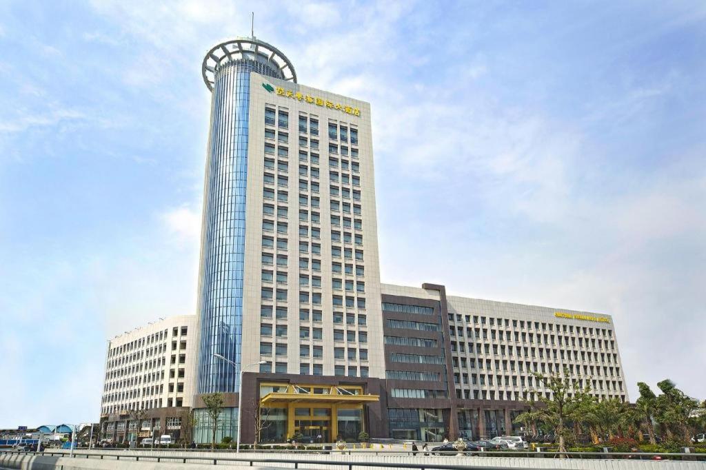 a large office building with a clock on top of it at Chutian Guangdong International Hotel in Wuhan