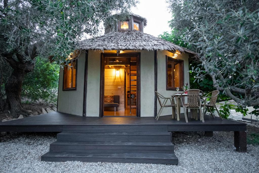 Una pequeña casa con techo de paja y una mesa y sillas. en Cabaña Etiopía, en Tarifa