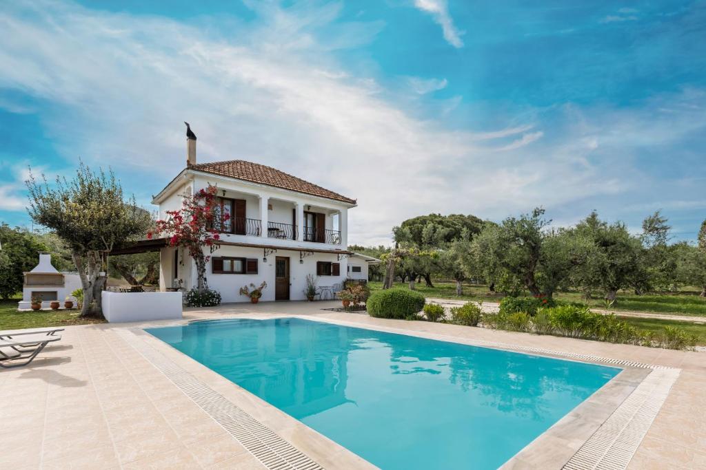 a villa with a swimming pool in front of a house at Villa Lola - 3 Bedrooms & Private Pool in Lithakia